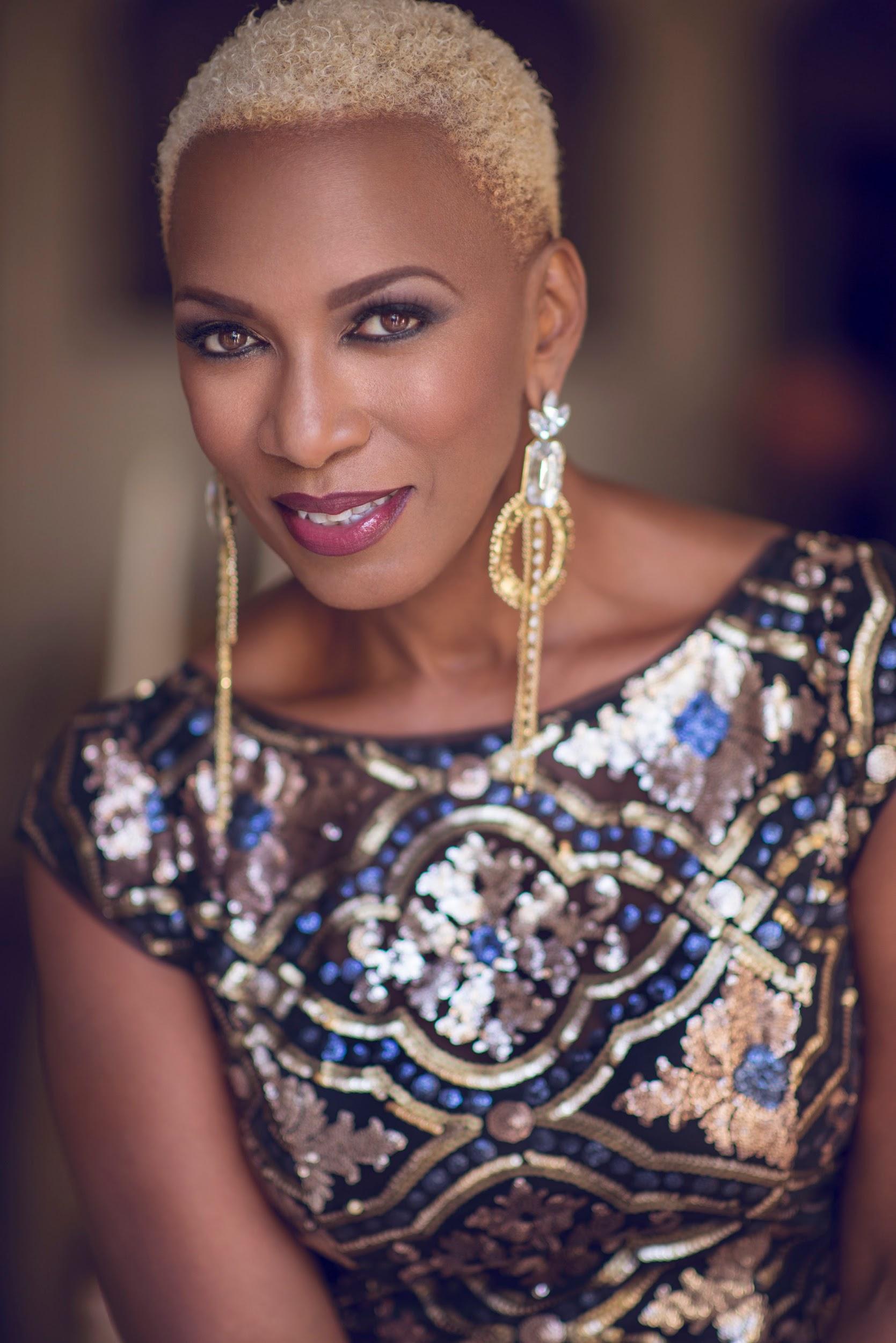 Portrait of Sisaundra Lewis in a black, gold, and silver embellished dress